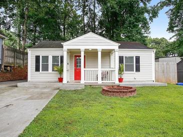 Charming single-story home featuring a classic design, a welcoming red door, and a well-manicured lawn at 1584 Carroll Nw Dr, Atlanta, GA 30318