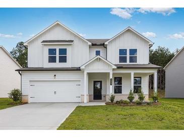 Charming two-story home boasts a modern design, manicured lawn, and inviting front porch at 205 Groveton Ct, Euharlee, GA 30145