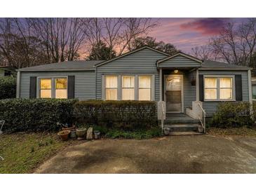 Charming single-story home with blue siding and landscaped front yard and an inviting front porch at 1054 Shepherds Ne Ln, Atlanta, GA 30324