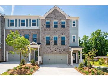Charming townhome with a two-car garage, attractive brickwork, and a well-maintained front yard at 1745 Lansmere Sw St, Marietta, GA 30008