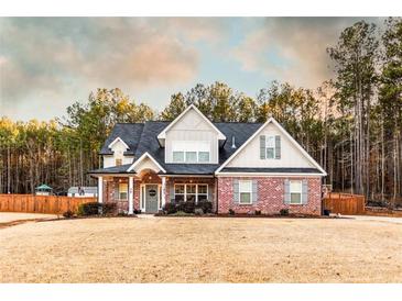 Charming two-story home with a brick facade, covered porch, and professionally landscaped yard at 35 Rock Rose Dr, Covington, GA 30014