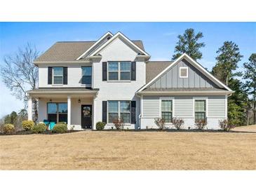 Charming two-story home with white brick and siding, black shutters, and a welcoming front porch at 6801 Louis Dr, Locust Grove, GA 30248