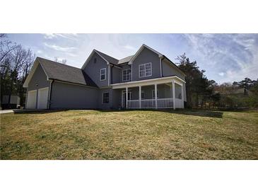 Charming two-story home features a welcoming front porch and an attached two-car garage at 70 Woodcliff Way, Covington, GA 30014