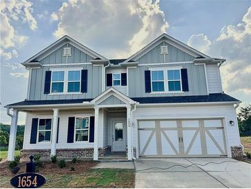 Beautiful two-story home featuring a two-car garage, classic shutters, and a covered front porch at 1654 Tide Mill Rd, Cumming, GA 30040