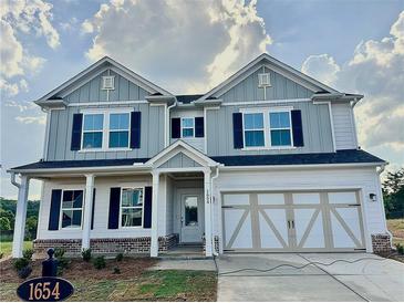 Charming two-story home with gray and white exterior, front porch, and a two-car garage at 1654 Tide Mill Rd, Cumming, GA 30040
