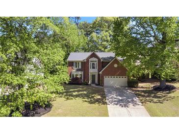 Charming two-story brick home with well-maintained landscaping and mature trees at 3595 Evonvale Overlook, Cumming, GA 30041