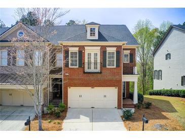 Charming brick townhome featuring a two-car garage and traditional architectural details at 1111 Newpark View Pl, Mableton, GA 30126