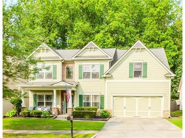 Charming two-story home featuring light green siding, green shutters, and a well-manicured lawn at 4273 Creekrun Cir, Buford, GA 30519