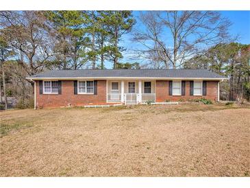 Charming single-story brick home featuring a welcoming front porch and well-maintained landscaping at 999 Chestnut Oak Ct, Lawrenceville, GA 30046