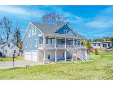 Charming two-story home with a spacious porch, and a two-car garage, set on a lush green lawn at 2002 Wingate Rd, Atlanta, GA 30341