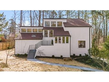 Modern home exterior featuring a white facade, dark trim, and a landscaped front yard at 2626 Shadow Woods Ne Cir, Marietta, GA 30062