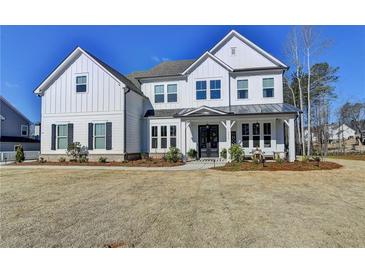 Stunning two-story white farmhouse with black trim and inviting front porch at 3820 Reserve Overlook Way, Cumming, GA 30041