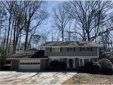 Traditional two-story home with a brick and siding exterior and attached two-car garage at 4617 N Peachtree Rd, Dunwoody, GA 30338