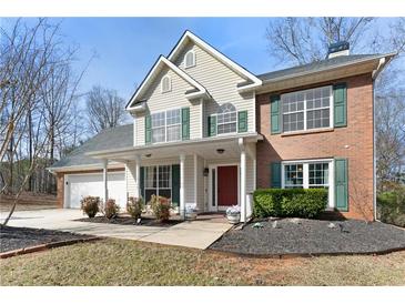 Charming two-story home with brick and siding, a well-manicured lawn, and a welcoming front porch at 1007 Crown River Pkwy, Mcdonough, GA 30252