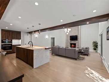 Open-concept living room featuring a kitchen island, fireplace, and hardwood floors at 2153 Starfire Drive Ne Dr, Atlanta, GA 30345
