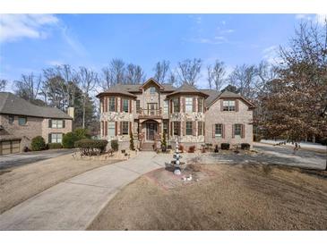 Impressive stone home featuring a fountain, manicured landscaping, and a private driveway at 3017 Canton Pines, Marietta, GA 30068