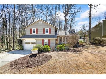 Charming two-story home with a well-maintained front yard and attached garage in a wooded neighborhood at 6038 Maryjo Ln, Norcross, GA 30093