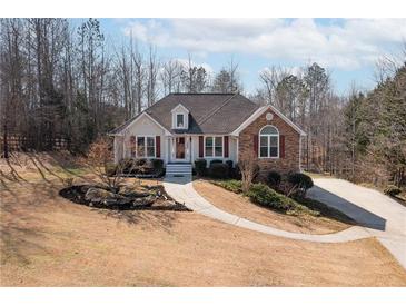 Charming single-story home featuring a manicured lawn, red shutters, and stone accents at 6935 Autumn Hills Dr, Cumming, GA 30028