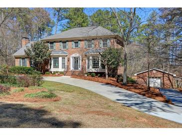 Charming two-story brick home featuring a long driveway and a detached garage at 3970 Brenteresa Ct, Snellville, GA 30039