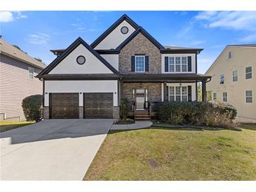 Charming two-story home featuring a two-car garage and a beautifully landscaped front yard on a sunny day at 7382 Gossamer St, Union City, GA 30291