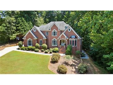 Stately brick home boasts meticulous landscaping and a welcoming entrance, set amid mature trees at 2287 Lake Ridge Ter, Lawrenceville, GA 30043