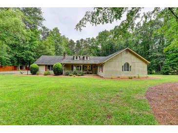 Charming home featuring a well-maintained lawn, mature trees and a welcoming front porch at 637 Rock Springs Rd, Lawrenceville, GA 30043