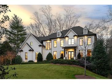 Stunning white brick home features black trim, lush green lawn, and manicured landscaping at 4555 Mystic Dr, Atlanta, GA 30342