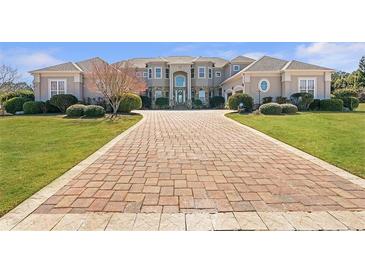 Stunning home featuring a large brick driveway, manicured lawn, and grand entrance with a portico at 525 Waters Way, Fayetteville, GA 30215