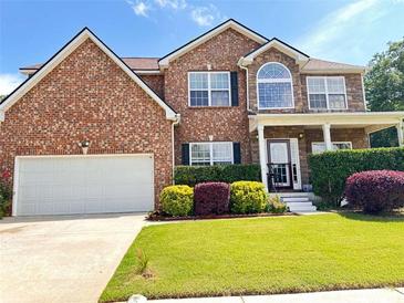 Charming two-story brick home featuring a well-manicured lawn and a two car garage at 4038 Se Clay Court Se Se, Conyers, GA 30013