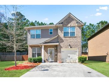 Charming two-story home with a well-maintained front yard and a combination brick and siding exterior at 5884 Grande River Rd, Atlanta, GA 30349
