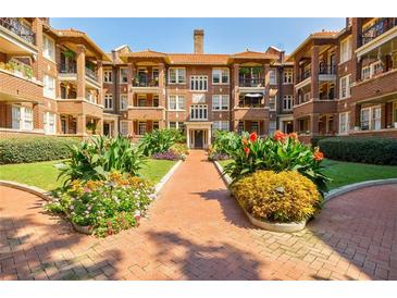 Beautiful courtyard entrance to a red brick apartment building with mature landscaping at 198 Ponce De Leon Ne Ave # 5D, Atlanta, GA 30308