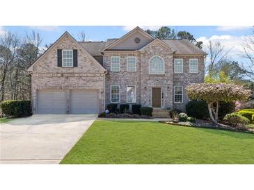 Charming brick two-story home with a well-manicured lawn and a two-car garage at 330 Meadowcrest Cir, Canton, GA 30115