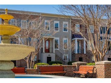 Charming townhome exterior featuring a water fountain, brick accents, and well-maintained landscaping at 961 Persimmon Pt, Atlanta, GA 30328