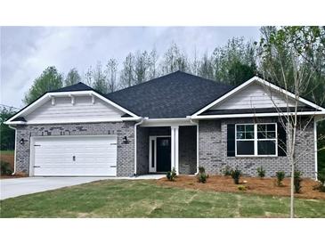 Charming brick home featuring a two-car garage, landscaped front yard, and covered entrance at 113 Scarlett Place Dr, Bowdon, GA 30108
