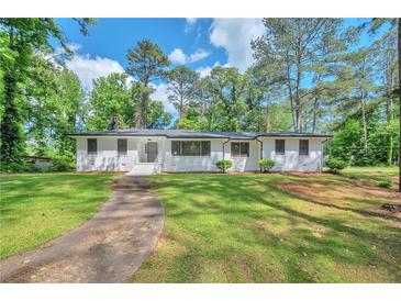 Charming one-story home with a well-manicured lawn and inviting walkway, surrounded by mature trees at 1332 Willis Mill Sw Rd, Atlanta, GA 30311