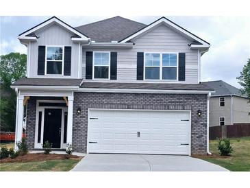 Charming two-story home featuring gray siding, brick accents, black shutters, and a two-car garage at 145 Scarlett Place Dr, Bowdon, GA 30108