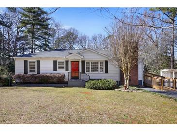 Charming single-story home with a red front door, black shutters, and landscaped front yard at 5812 Dogwood Cir, Austell, GA 30168