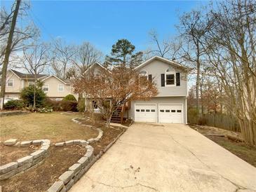 Charming split-level home featuring a two-car garage and landscaped front yard at 832 Overlook Trl, Canton, GA 30115