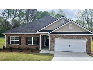 Charming one-story brick home with a two-car garage and well-manicured lawn, creating an inviting curb appeal at 112 Scarlett Place Dr, Bowdon, GA 30108
