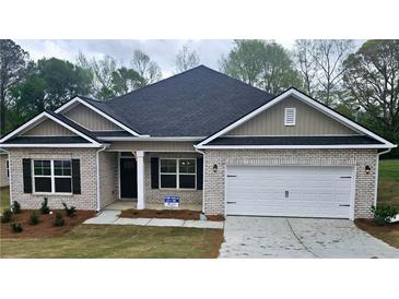 Charming single-story brick home featuring a two-car garage and well-maintained front yard at 116 Scarlett Place Dr, Bowdon, GA 30108