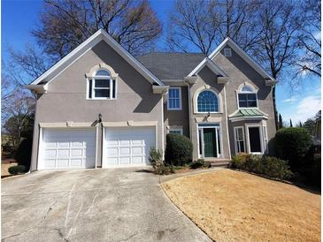 Two-story stucco home with an attached two-car garage and a well-manicured front lawn at 2899 Greystone Cv, Chamblee, GA 30341