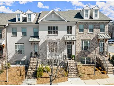 Townhome exterior showcasing brick facade, covered entryways, and landscaped front yards on a sunny day at 4000 Bethelview Ln, Suwanee, GA 30024