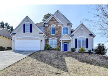 Charming two-story home with stone accents, a blue front door, and a well-manicured front yard at 1541 Towne Park Ct, Lawrenceville, GA 30044