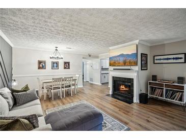 Cozy living room with a fireplace, dining area, and comfortable seating arrangement at 1605 Beaumont Cir, Duluth, GA 30096