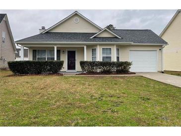 Charming single-story home featuring manicured landscaping and an attached garage at 163 Woodwind Way, Jonesboro, GA 30238