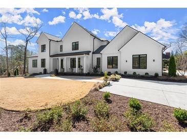 Stunning two-story white home featuring modern design elements and a well-manicured lawn with tasteful landscaping at 4100 Thunderbird Dr, Marietta, GA 30067
