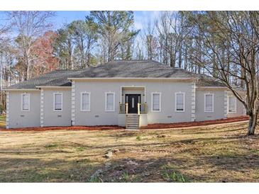 Charming single-story home with a well-manicured lawn and inviting front entrance at 6010 Canaan Woods Dr, South Fulton, GA 30331