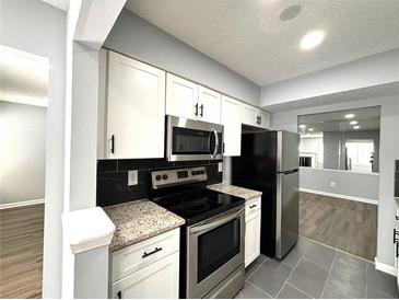 Modern kitchen featuring stainless steel appliances, white cabinets and granite countertops at 1502 Huntingdon Chase, Atlanta, GA 30350