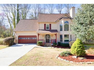 Charming two-story home featuring a well-manicured lawn, attached two car garage and inviting front porch at 3175 Pond Ridge Trl, Snellville, GA 30078