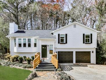 Charming two-story home featuring a well-manicured lawn, attached garage, and inviting front porch with steps at 4853 Chapelle Ct, Marietta, GA 30066
